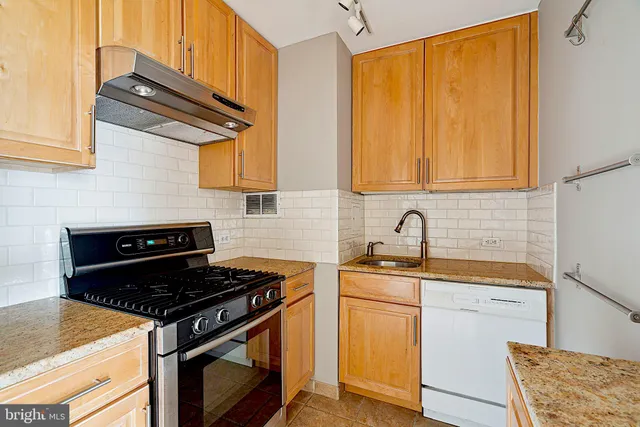 a kitchen with stainless steel appliances granite countertop a stove and a sink