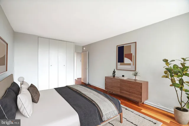 a bedroom with bed and a potted plant