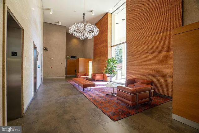 a living room with furniture a chandelier and a fireplace