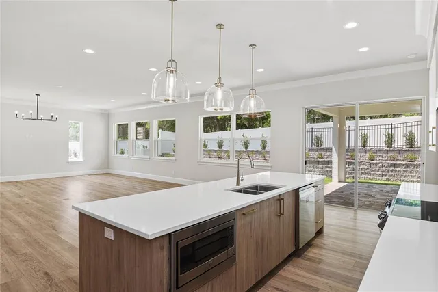 a kitchen with stainless steel appliances granite countertop a sink a stove and a wooden floors
