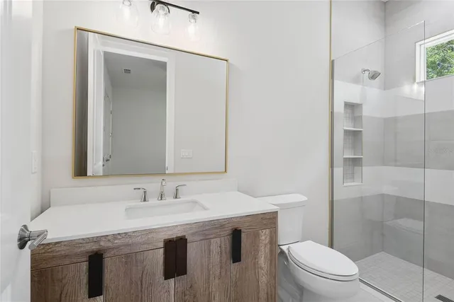 a bathroom with a granite countertop sink a toilet and shower