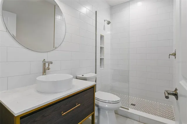 a bathroom with a sink a toilet and shower