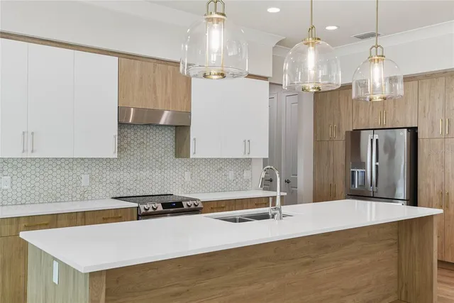 a kitchen with stainless steel appliances a refrigerator sink and white cabinets
