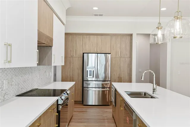 a kitchen that has a sink a stove and a refrigerator