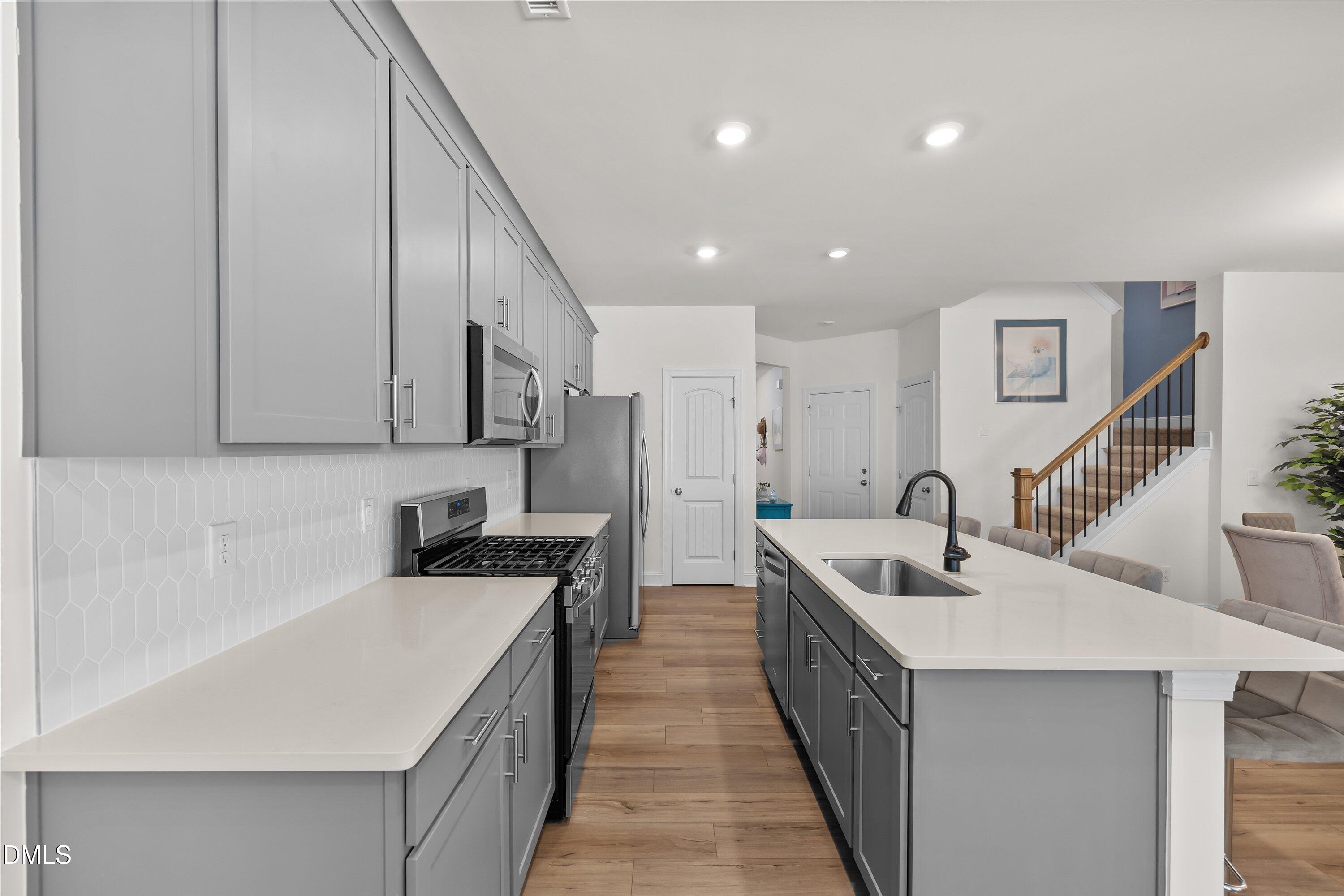 1014 Culloden Circle Durham, NC 27713 - Photo 13 of 32 a kitchen with stainless steel appliances a sink stove and cabinets