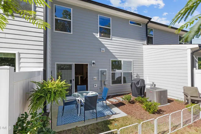 a view of backyard of house with outdoor seating and green space