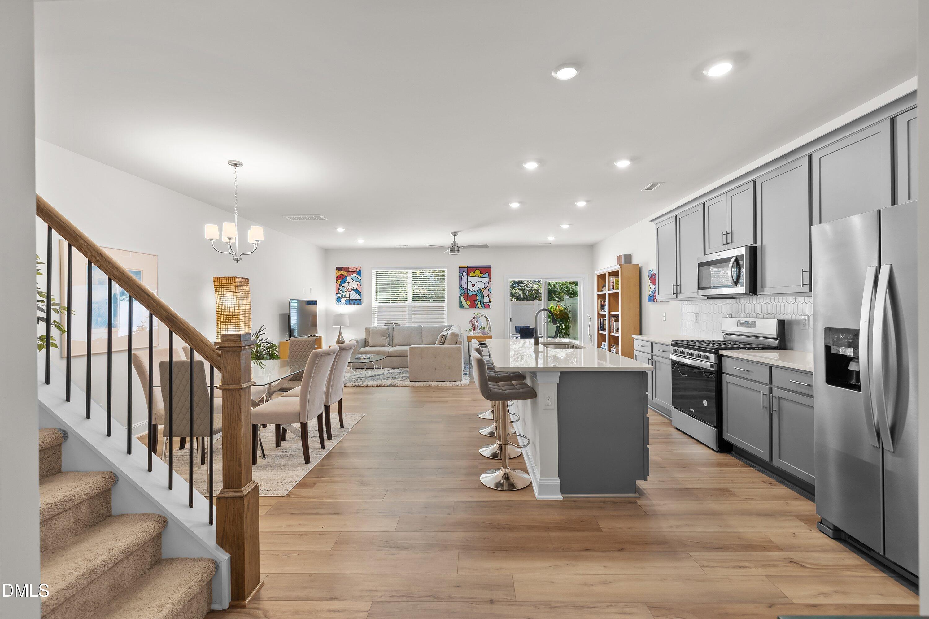 1014 Culloden Circle Durham, NC 27713 - Photo 4 of 32 a living room with stainless steel appliances kitchen island granite countertop a refrigerator a stove a dining table and chairs with wooden floor