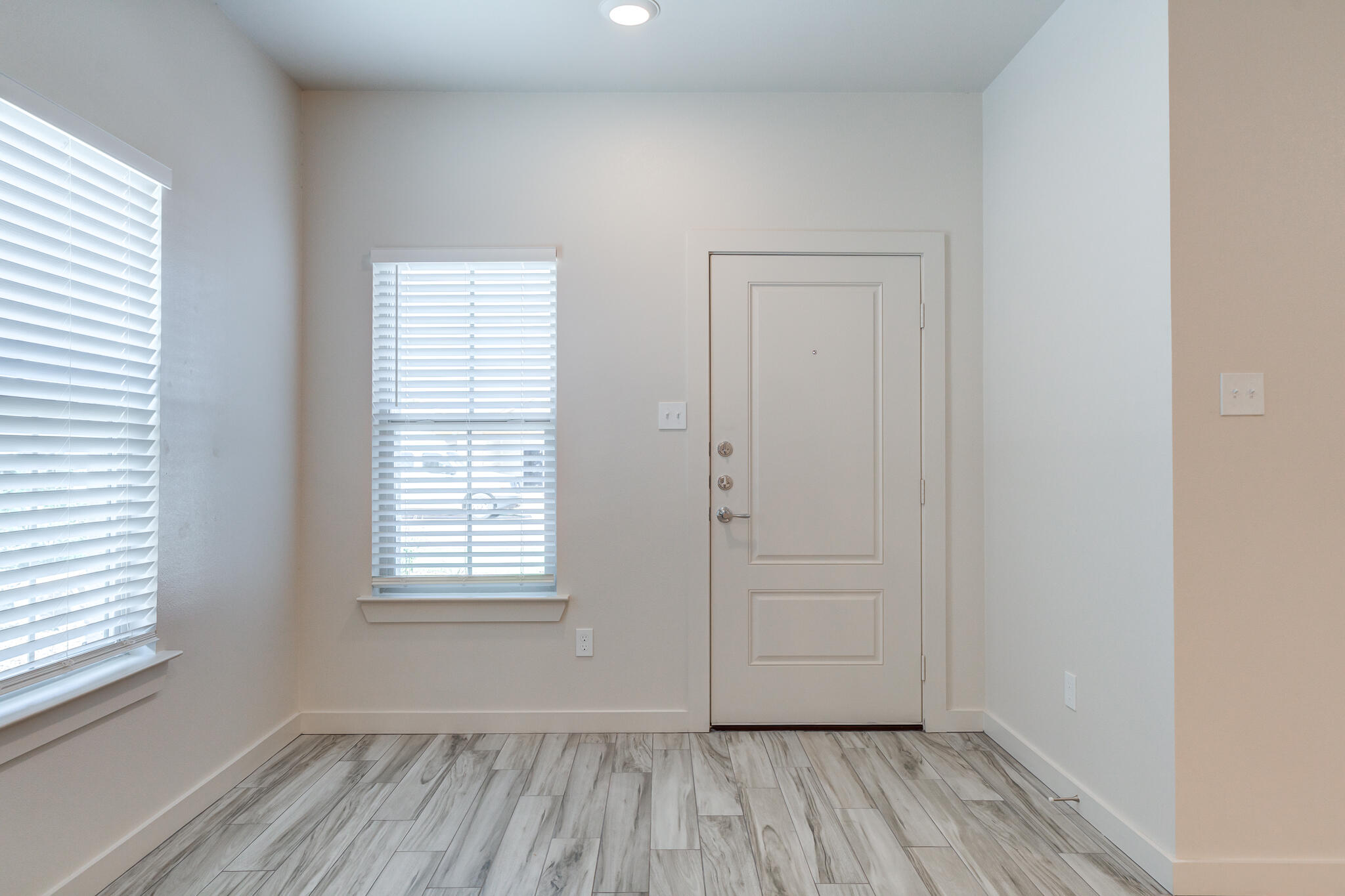 7046 41st Street Lubbock, TX 79407 - Photo 3 of 28 an empty room with wooden floor and windows