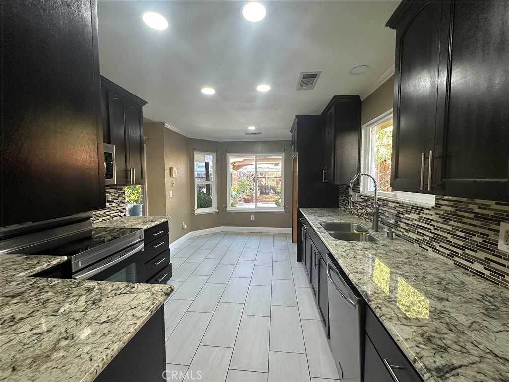 5409 Covert Road Salida, CA 95368 - Photo 10 of 23 a large kitchen with kitchen island granite countertop a large counter top and stove