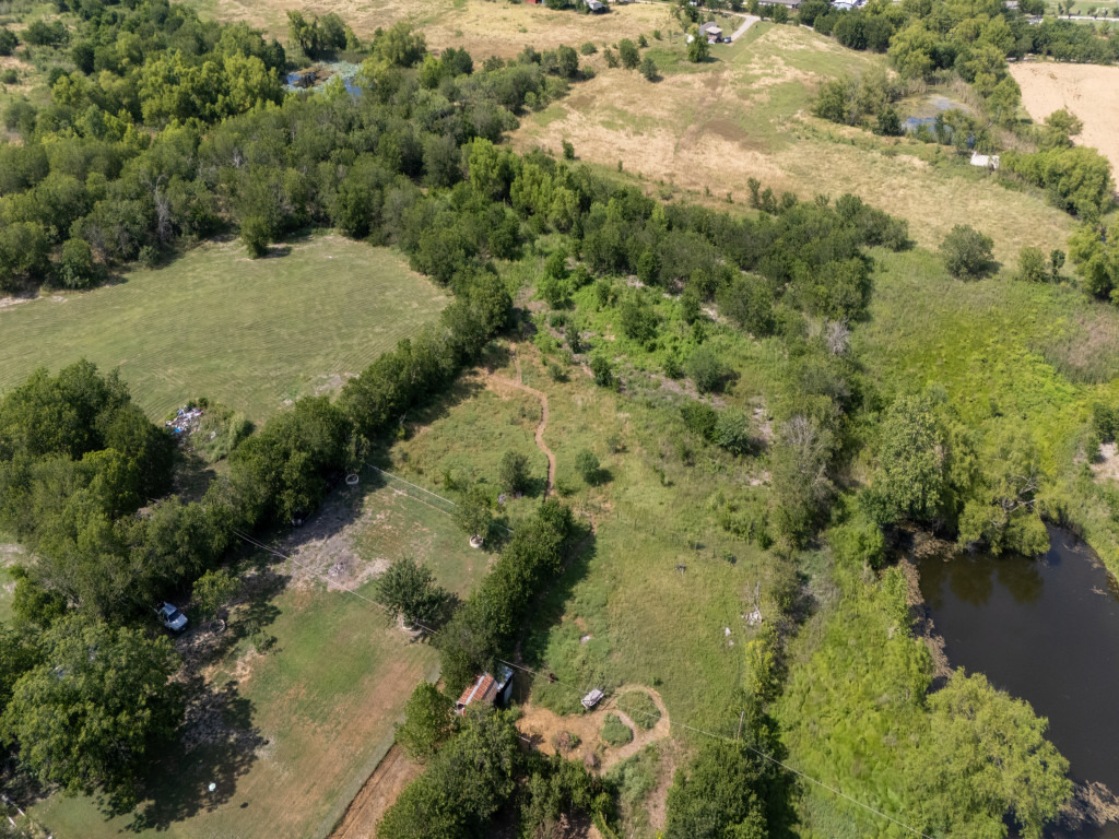 1035 Palomino Road Kyle, TX 78640 - Photo 10 of 13 Explore this expansive, well-maintained land parcel featuring a natural pond and lush green fields.