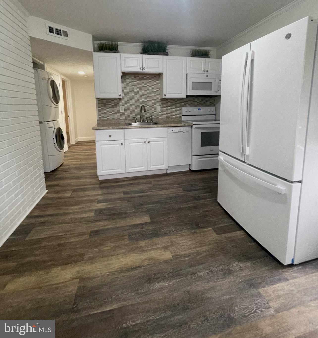 5700 Stillwell Road Rockville, MD 20851 - Photo 7 of 19 a kitchen with stainless steel appliances a refrigerator sink and cabinets