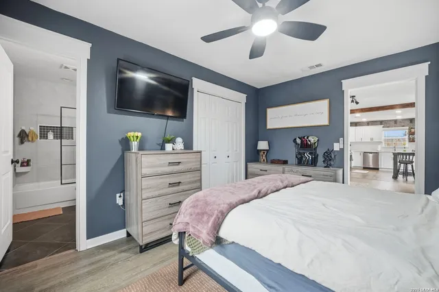 a spacious bedroom with a bed and a flat screen tv