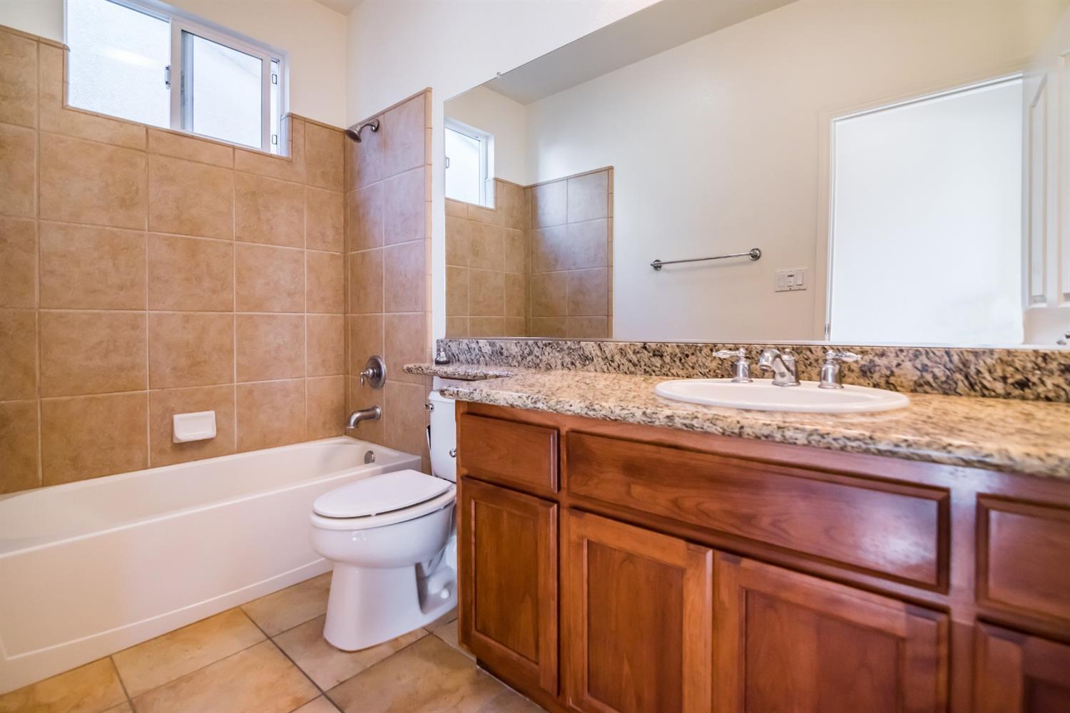 11737 Brook Valley Way Rancho Cordova, CA 95742 - Photo 12 of 25 a bathroom with a granite countertop toilet a sink and bathtub