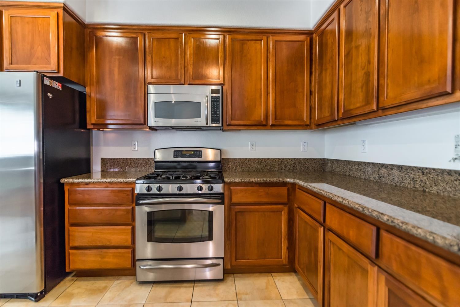 11737 Brook Valley Way Rancho Cordova, CA 95742 - Photo 15 of 25 a kitchen with stainless steel appliances granite countertop a stove a microwave and a refrigerator