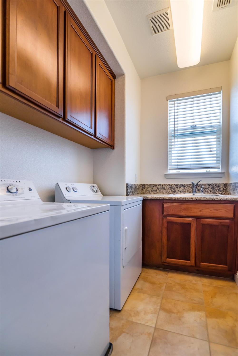 11737 Brook Valley Way Rancho Cordova, CA 95742 - Photo 17 of 25 a kitchen with stainless steel appliances granite countertop a sink and cabinets with wooden floor