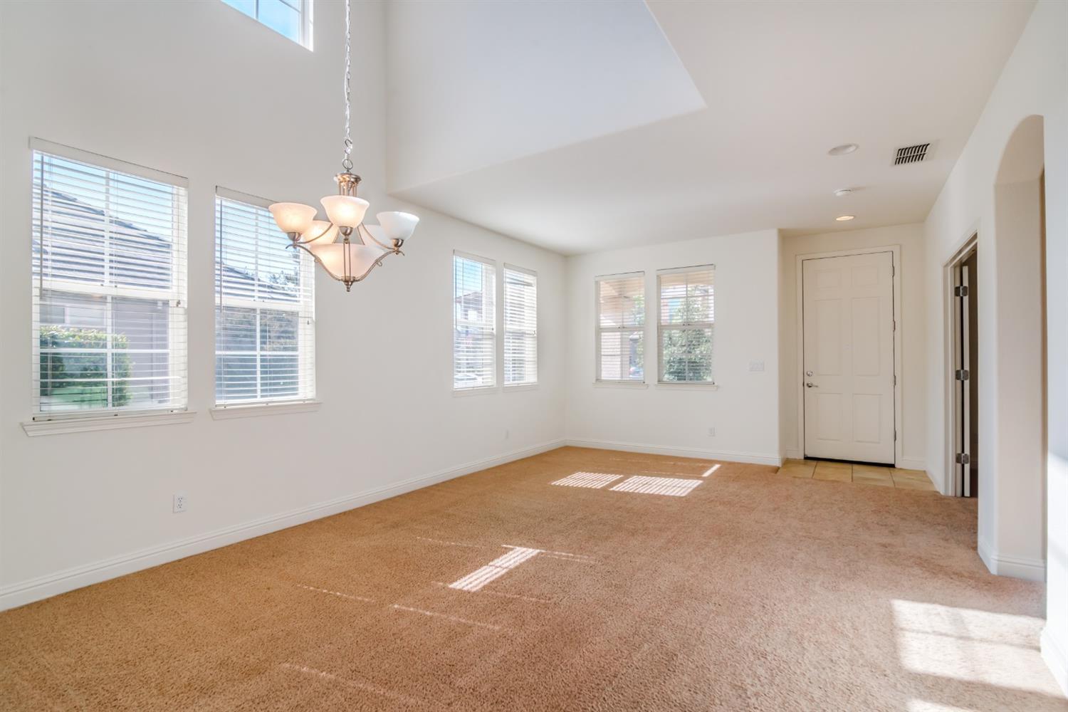 11737 Brook Valley Way Rancho Cordova, CA 95742 - Photo 6 of 25 an empty room with windows and chandelier fan