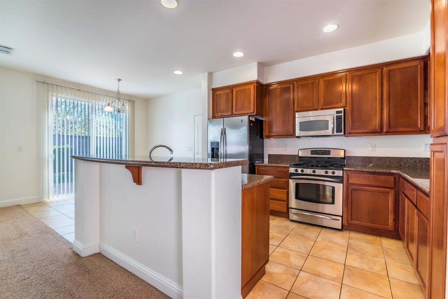 11737 Brook Valley Way Rancho Cordova, CA 95742 - Photo 7 of 25 a kitchen with stainless steel appliances granite countertop a stove a sink and a refrigerator