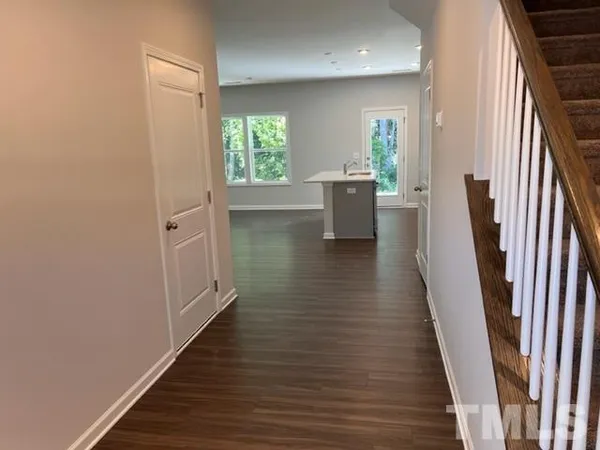 a view of a hallway with wooden floor and staircase