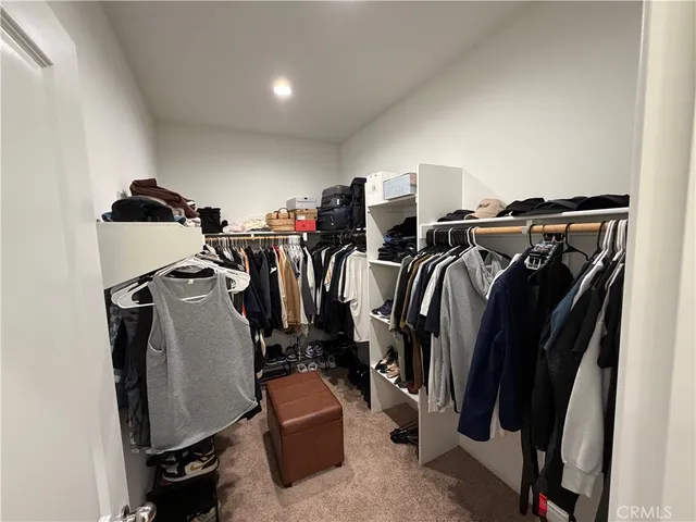 a view of walk in closet with clothes and shoes
