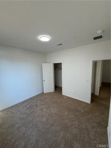 an empty room with closet and windows