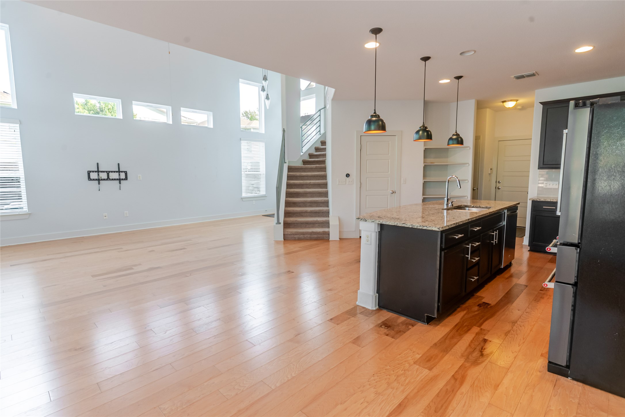 1400 Homespun Road Austin, TX 78745 - Photo 6 of 30 Gleaming hardwood floors and a central granite island define this airy open-concept living space.