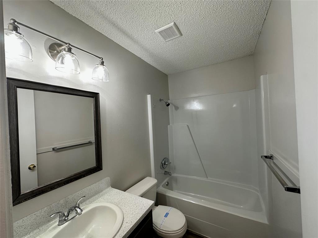 2006 Jane Street, Unit D Longview, TX 75601 - Photo 11 of 12 a bathroom with a toilet sink and a mirror