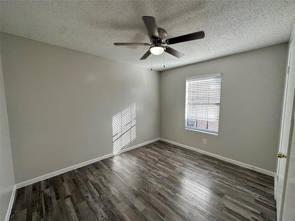 2006 Jane Street, Unit D Longview, TX 75601 - Photo 6 of 12 an empty room with wooden floor fan and windows