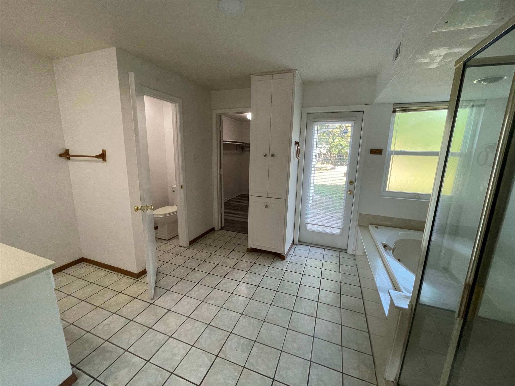 5802 Longhorn Landing Austin, TX 78734 - Photo 27 of 38 Bathroom featuring vanity, a garden tub, a shower stall, light tile patterned flooring, and a walk in closet