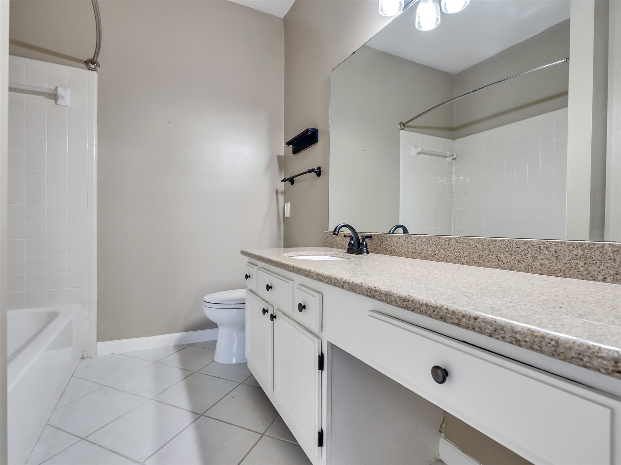 4001 Tanglewilde Street, Unit 605 Houston, TX 77063 - Photo 18 of 29 a spacious bathroom with a granite countertop sink a toilet and a mirror