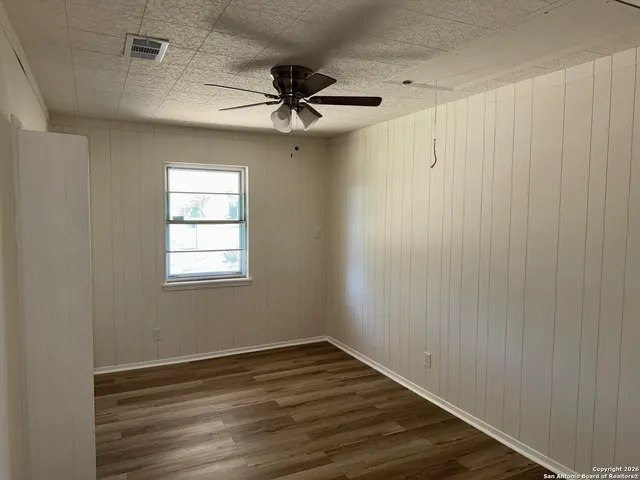 a view of an empty room with wooden floor