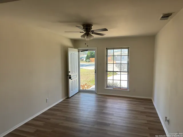 wooden floor in an empty room with a window