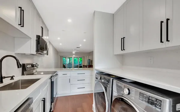 a kitchen with a sink a stove cabinets and a wooden floor