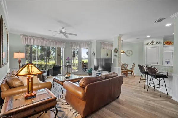 a living room with furniture a rug and a floor to ceiling window