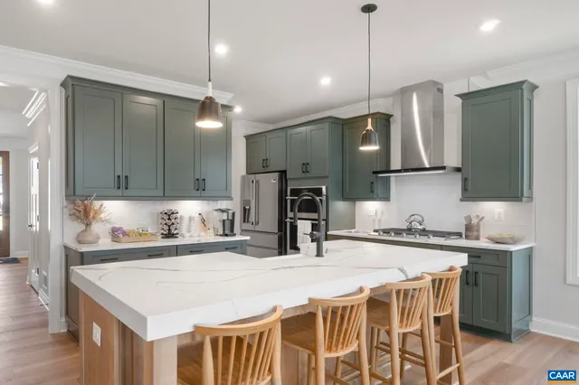 a kitchen with a sink a center island cabinets and stainless steel appliances