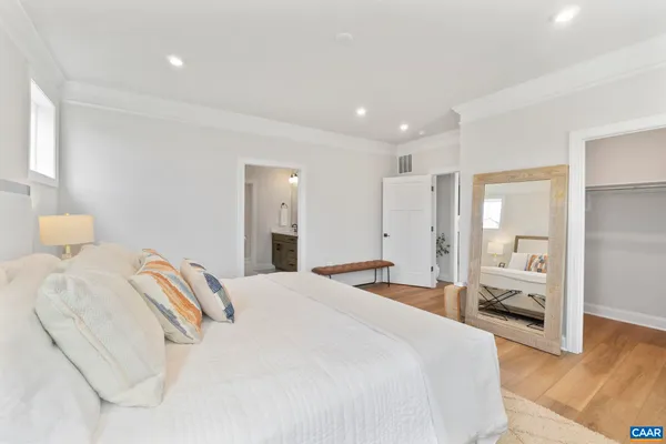 a spacious bedroom with a bed and a large mirror
