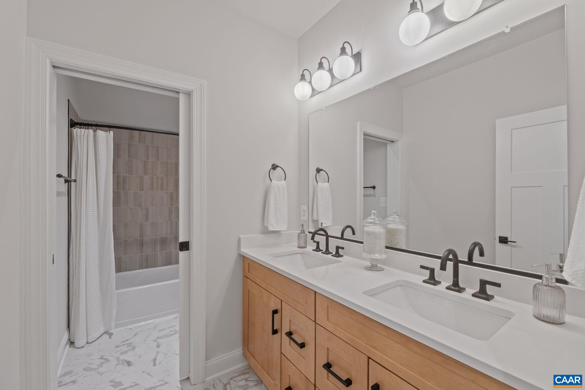 109 Marcella Street Charlottesville, VA 22911 - Photo 40 of 49 a bathroom with a double vanity sink a mirror and a bathtub