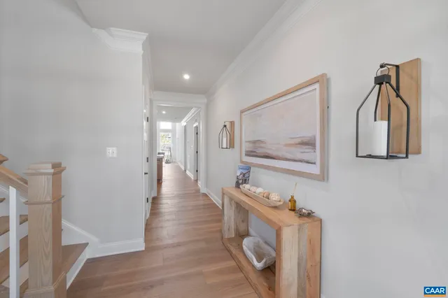 a view of a hallway with wooden floor and cabinet