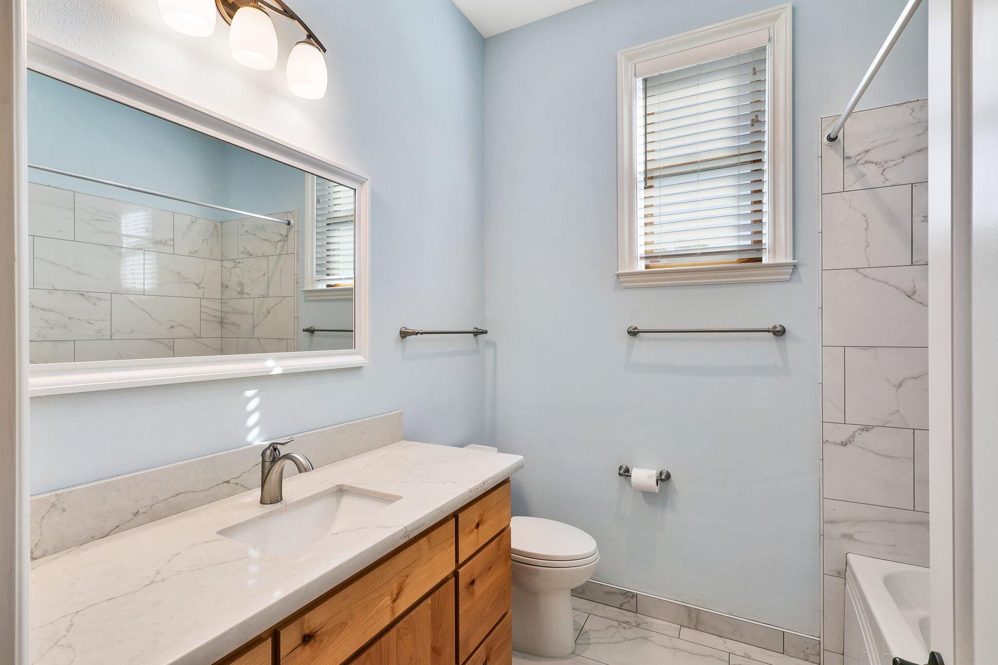 3211 Lake Redding Drive Redding, CA 96003 - Photo 28 of 68 a bathroom with a granite countertop sink toilet a mirror and a window