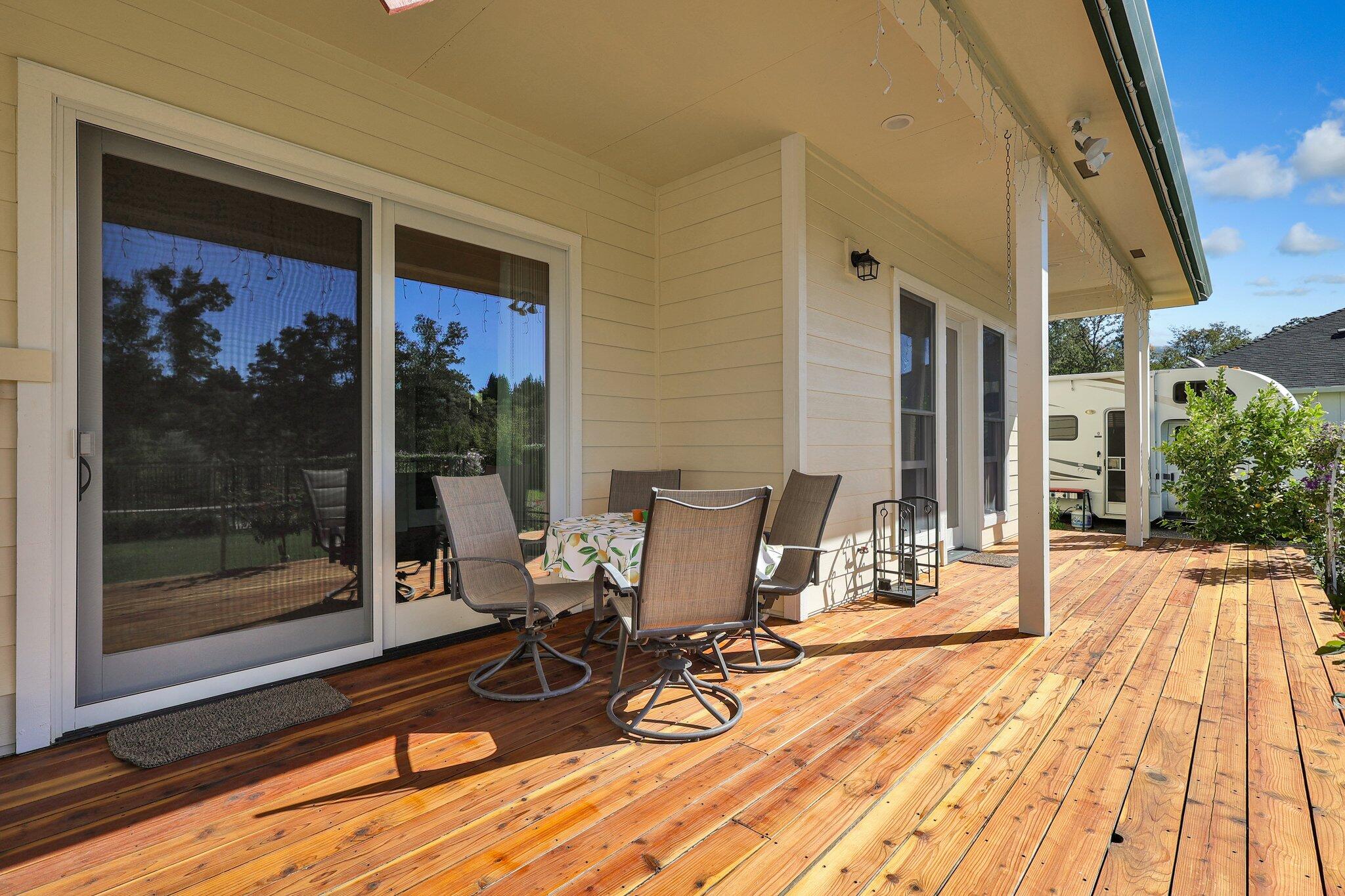 3211 Lake Redding Drive Redding, CA 96003 - Photo 34 of 68 a view of a patio with table and chairs and floor to ceiling window with wooden floor