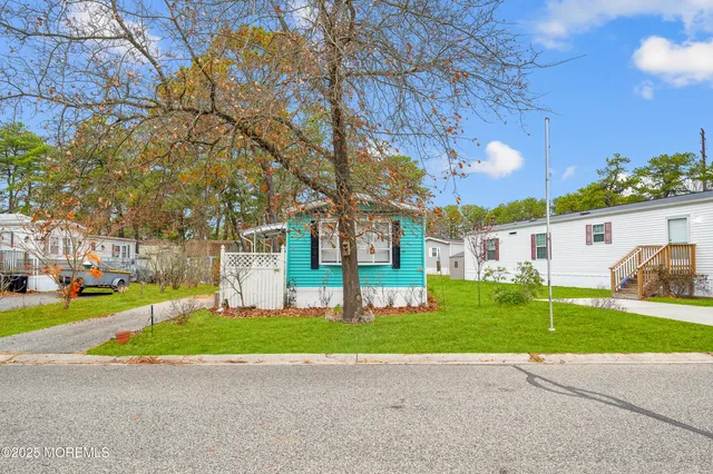 a view of a house with a big yard and large trees