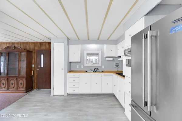 a large kitchen with stainless steel appliances granite countertop a refrigerator and a sink