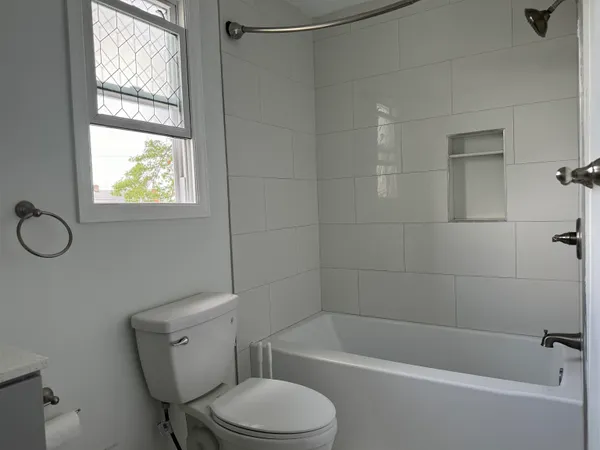 a white toilet sitting next to a bath tub shower