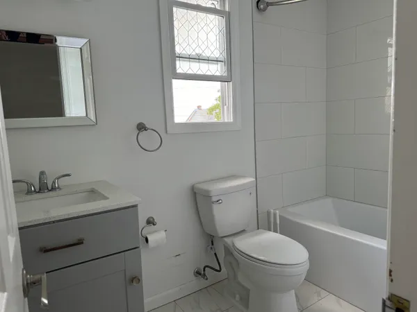 a bathroom with a sink toilet and window