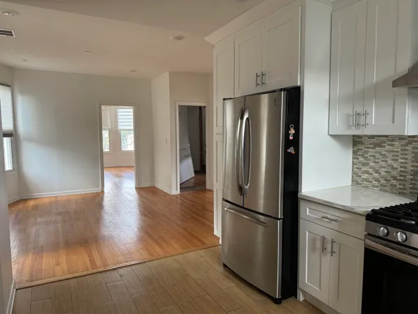 a kitchen with stainless steel appliances granite countertop a refrigerator a stove and a sink
