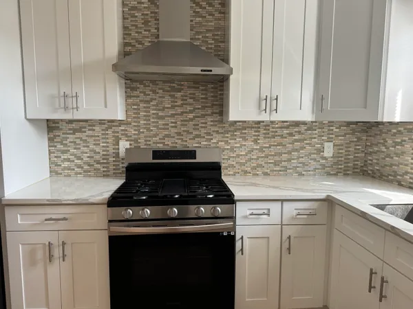 a kitchen with white cabinets and black appliances