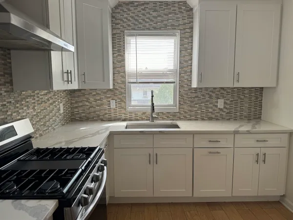 a kitchen with white cabinets appliances and a sink