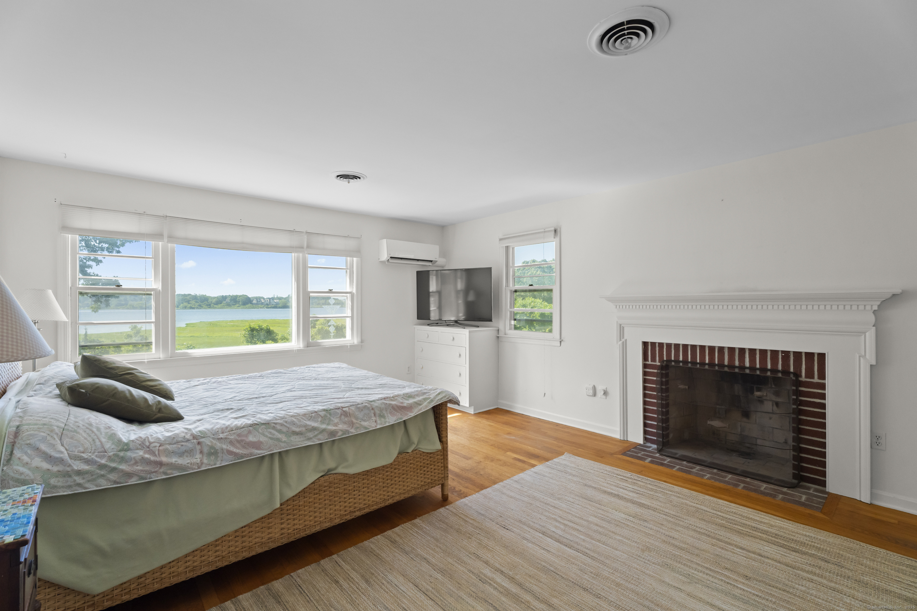 301 Osbrook Point Stonington, CT 06379 - Photo 16 of 39 a bedroom with a bed a fireplace and a large window