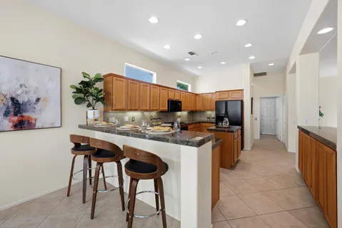 a kitchen with stainless steel appliances granite countertop a refrigerator and a stove top oven