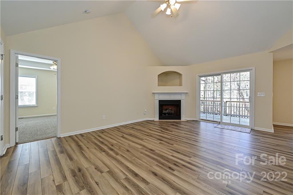 517 Kittiewake Lane Clover, SC 29710 - Photo 18 of 30 an empty room with wooden floor fireplace and windows