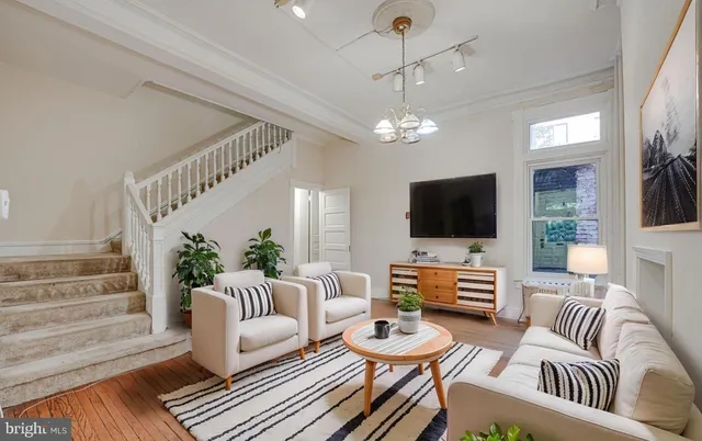 a living room with furniture chandelier and a flat screen tv